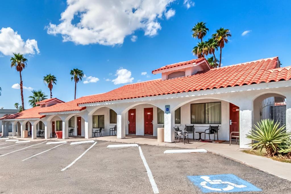 a building with a red roof and palm trees at Historic Coronado Motor Hotel by OYO in Yuma