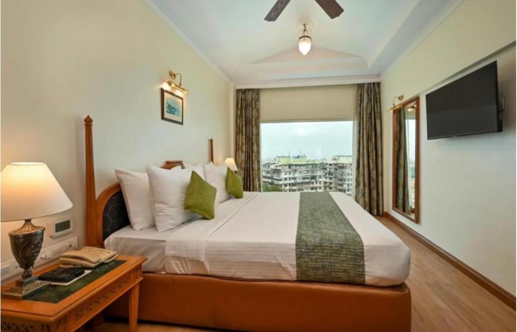 une chambre avec un grand lit avec une grande fenêtre dans l'établissement Hotel Red Plaza -Near Delhi Airport & Free Airport Drop, à New Delhi