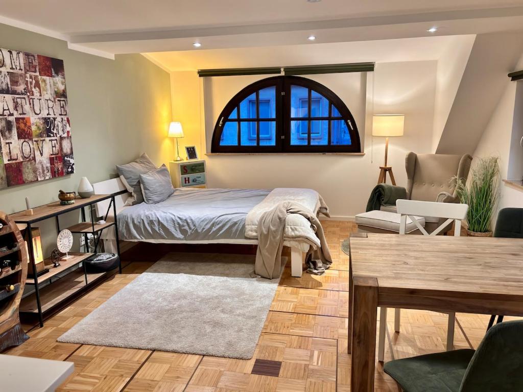Un dormitorio con una cama y una mesa y una ventana. en Unique apartment near Frankfurt, en Neu Isenburg