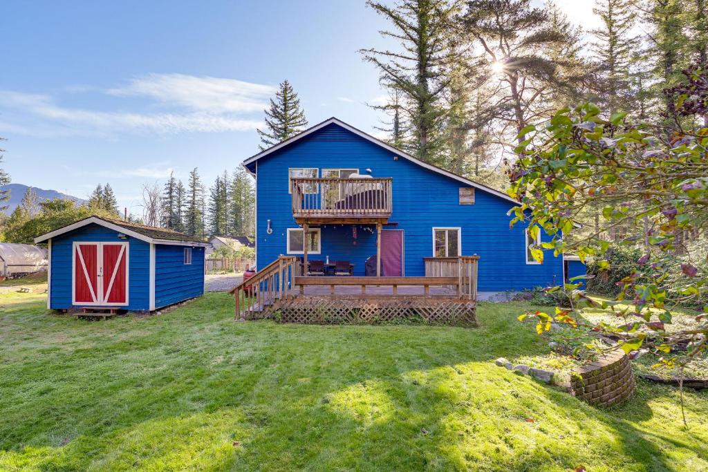 une maison bleue avec une terrasse et une cour dans l'établissement Fire Pit and Mountain Views Outdoorsy PNW Escape, à Gold Bar