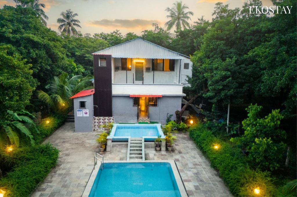 a villa with a swimming pool in front of a house at EKOSTAY - Fern Wood Villa 