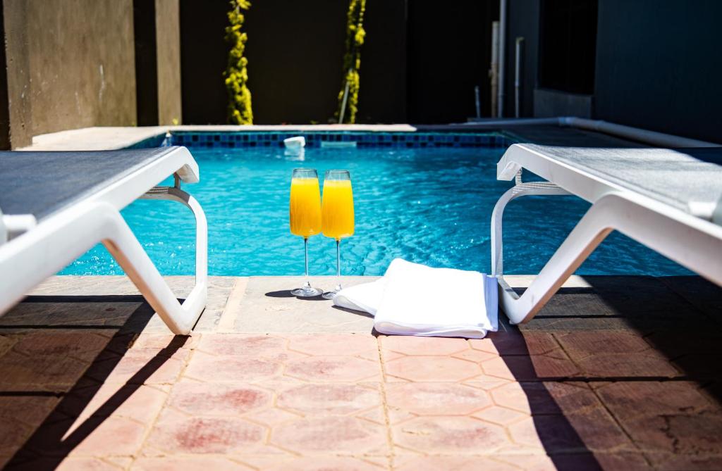 two yellow candles sitting next to a swimming pool at Makupula Apartments in Lusaka