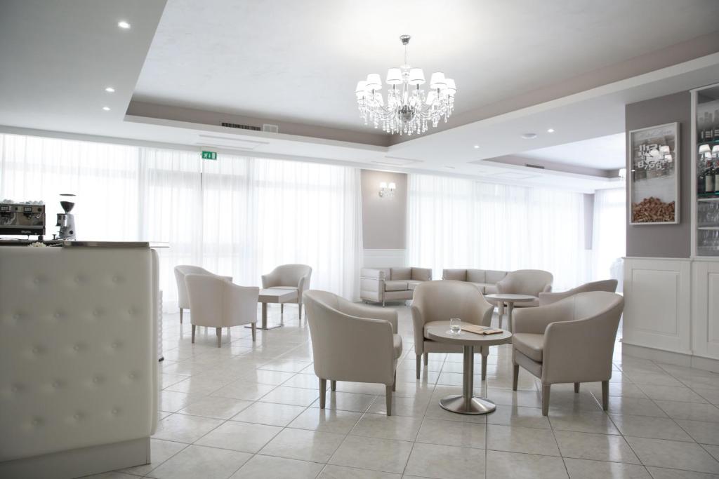 a dining room with chairs and tables and a chandelier at Hotel Leon - Ristorante Al Cavallino Rosso in San Giovanni Rotondo