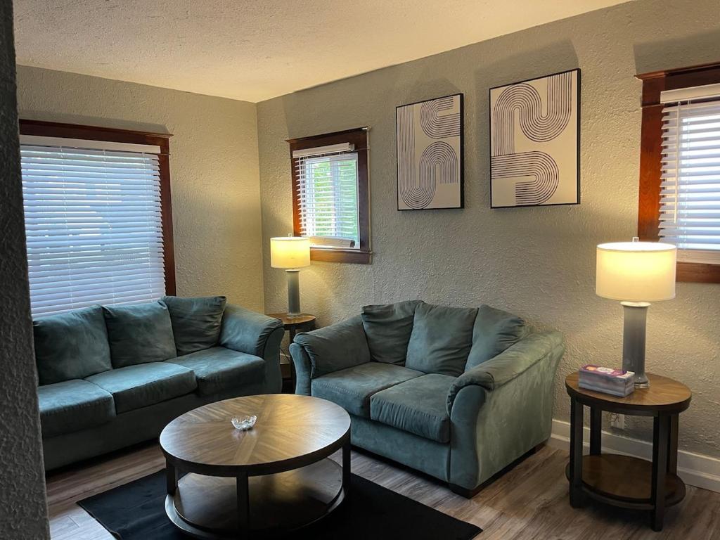 a living room with two couches and a table at Quiet 3 Bedroom home Near downtown in Lansing