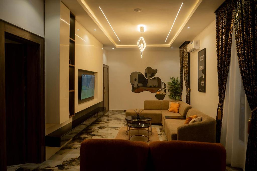 a living room with a couch and a guitar on the wall at Awka Luxury One Bed in Awka