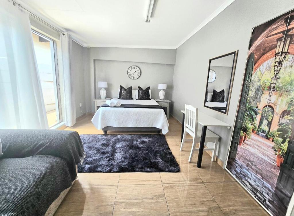 a bedroom with a bed and a clock on the wall at Zhantique Guest House 2- Unit 2 in Boksburg