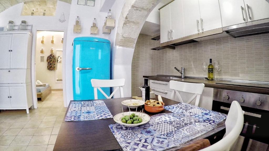 a kitchen with a table with a blue door at Monopoli Casa Vacanze in Monopoli