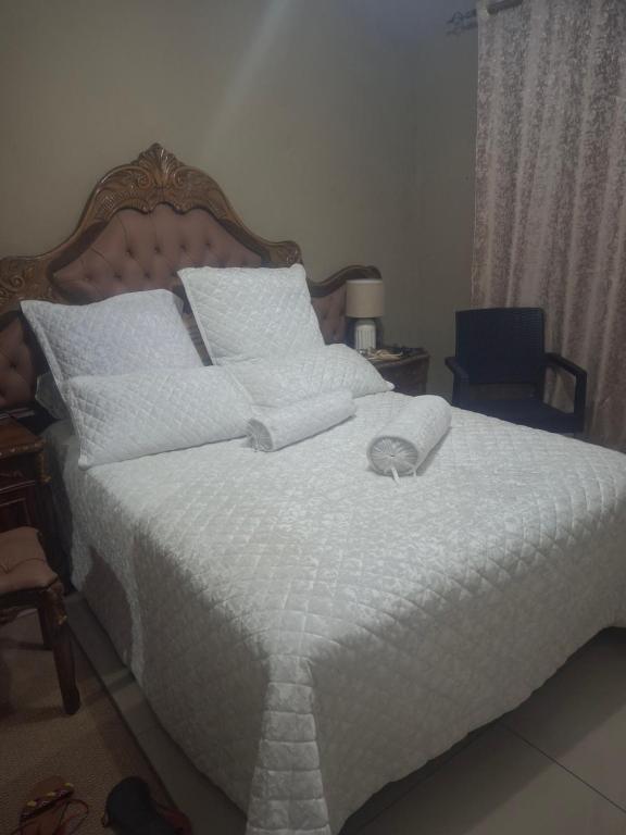 a bedroom with a large bed with a white comforter at Leopard Pezeld BnB in Louis Trichardt
