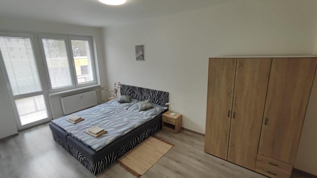 a bedroom with a bed and a wooden cabinet at Apartmán V Kraslicích pro 4 osoby, Pohraniční stráže in Kraslice