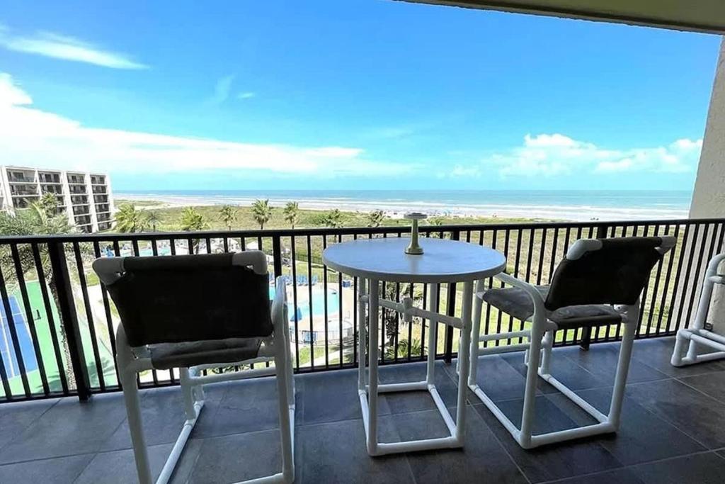 a balcony with a table and two chairs and the ocean at Top Floor Ultimate Beachfront Luxury Remodeled in South Padre Island