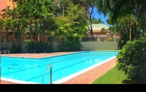 ein blauer Pool mit Bäumen im Hof in der Unterkunft Mar Azul Apartments in San Juan