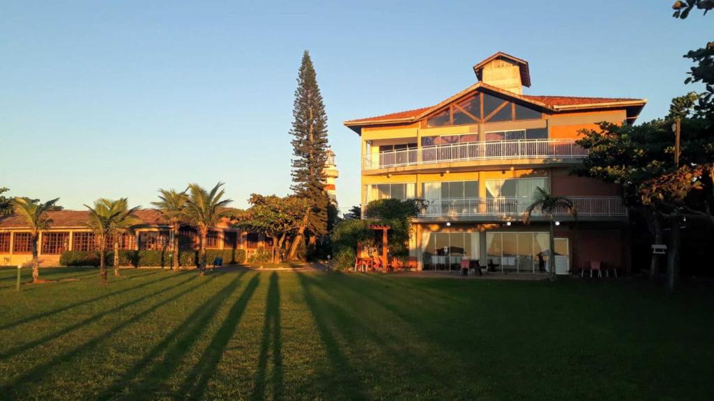 a large house with a lawn in front of it at Flamboyant Hotel in Barra Velha