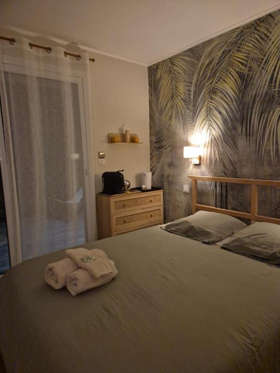 una camera da letto con un letto e un asciugamano sopra di Chez Hélène a Bordeaux