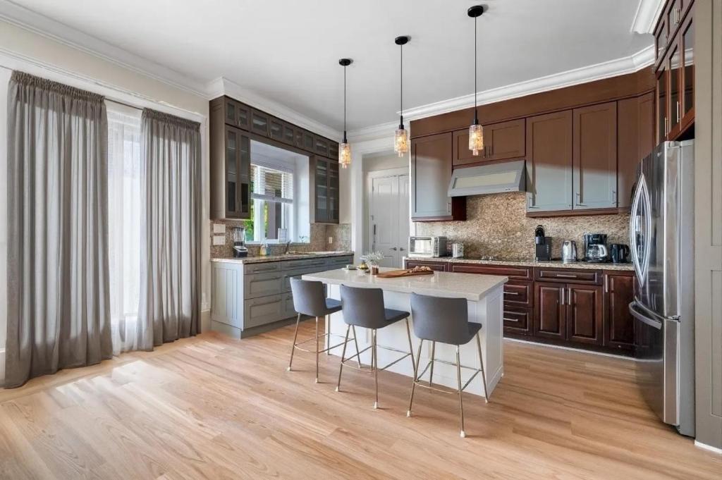 a kitchen with wooden cabinets and a island with bar stools at Share Home- Cozy Getaway in Vancouver in Vancouver