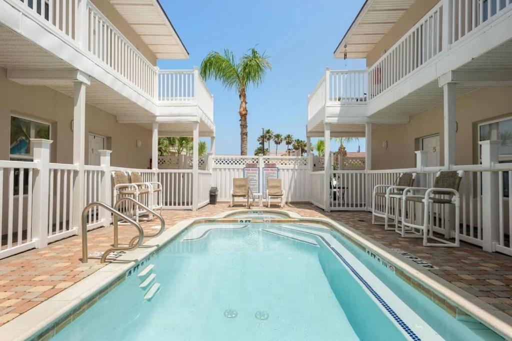 una piscina con sillas y una casa en 2 levels Big 3 bedroom Near Beach Pool, en South Padre Island