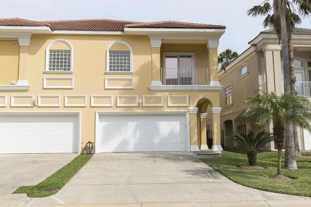 a large yellow house with two garage doors at Big Private Luxury Home in Beach Gated Community in South Padre Island