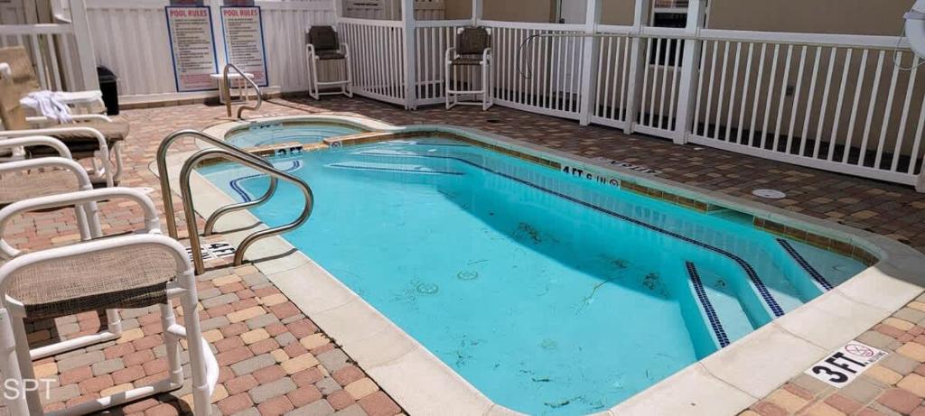 una piscina con 2 sillas alrededor en In Entertainment District Ample Bedding Pool, en South Padre Island