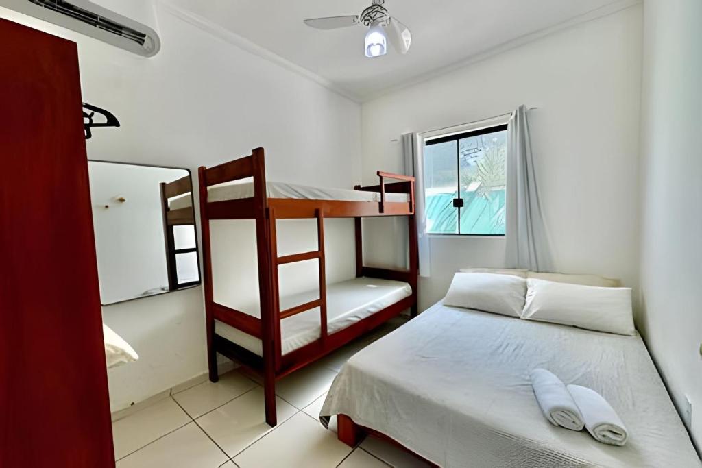 a bedroom with a bunk bed and a desk at Apartamentos Recanto da Barra in Ubatuba