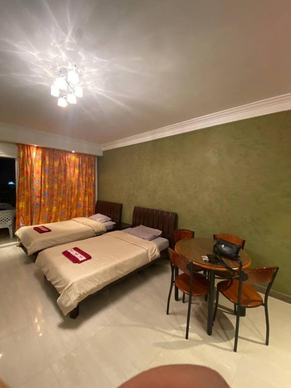 deux lits dans une chambre avec une table et une tableasteryasteryasteryasteryastery dans l'établissement Spacious apartment inside a resort, à Charm el-Cheikh