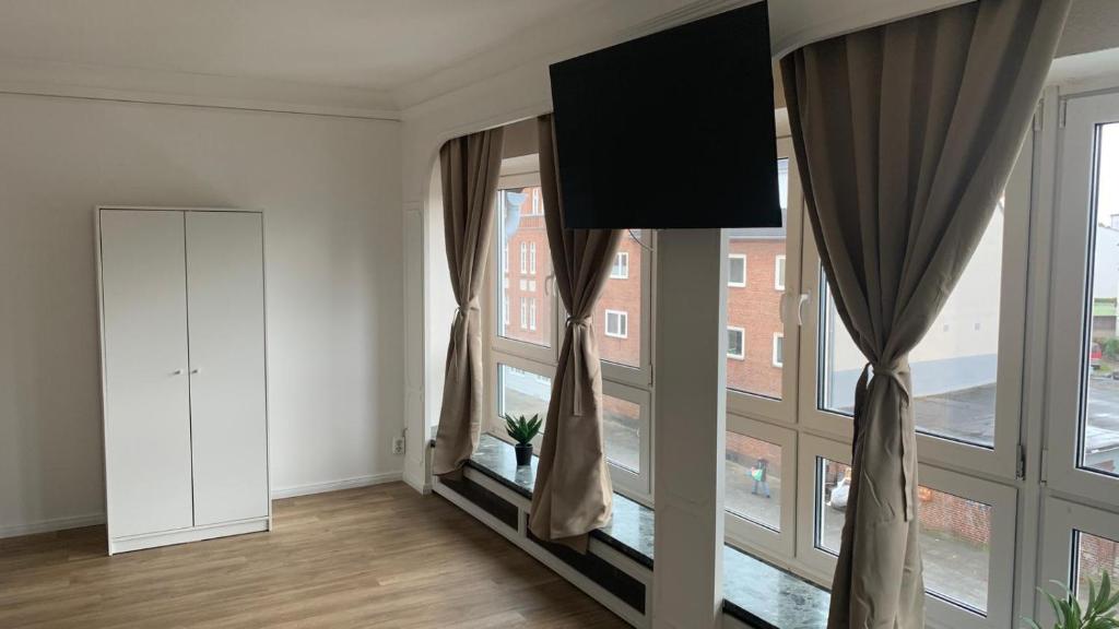 an empty living room with large windows at Lichtdurchflutetes City-Apartment im Herzen der Stadt in Neumünster