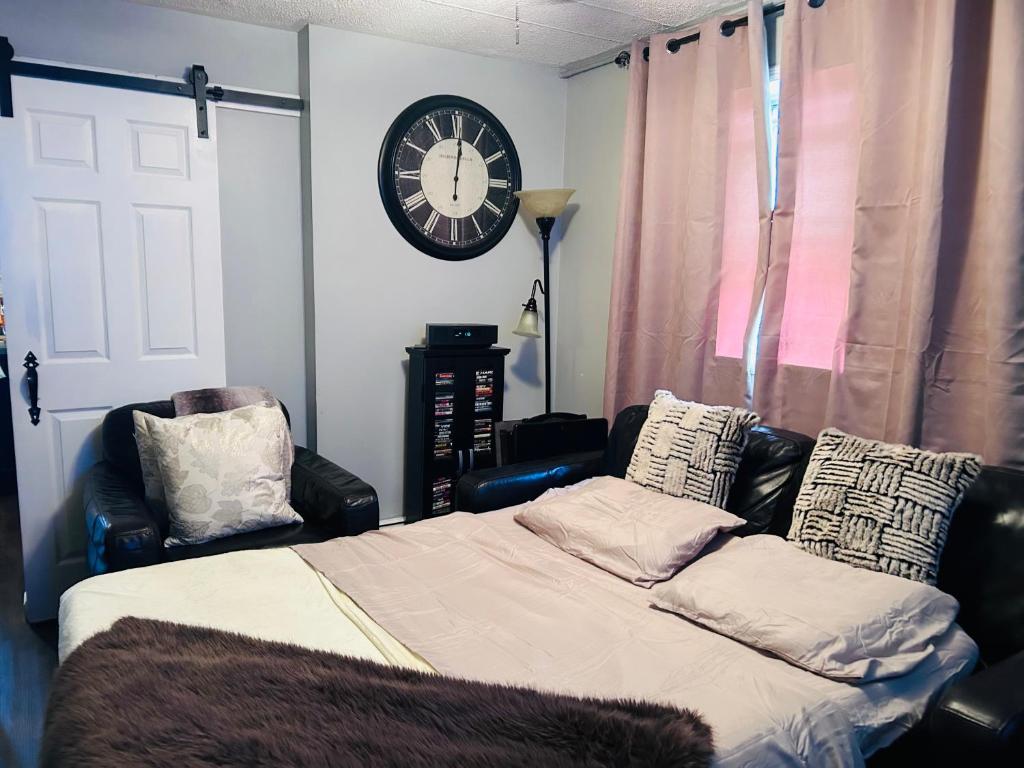 a bedroom with a bed and a clock on the wall at The Layover Lounge in Elizabeth