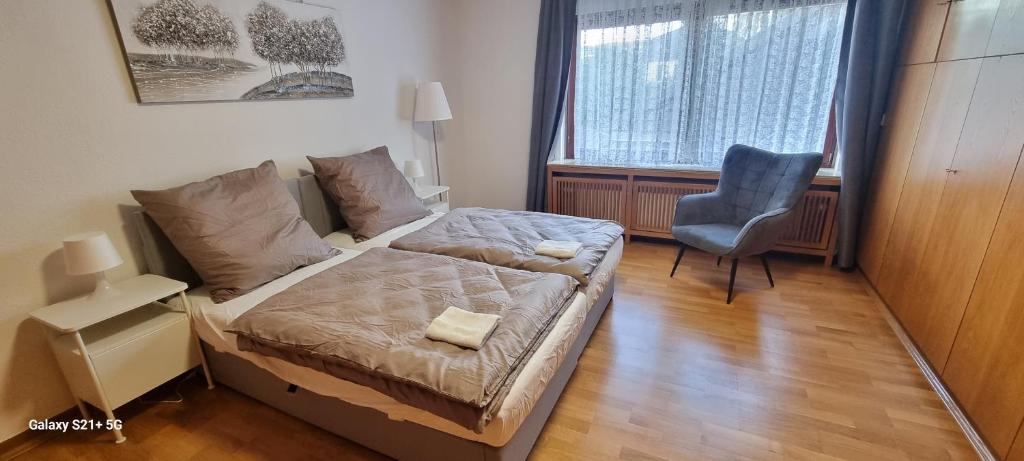 een kleine slaapkamer met een bed en een stoel bij Casaba Suite 2-150qm-4 Rooms-Free Private Parking-House with garden in Hannover