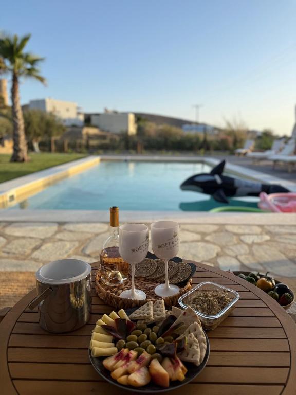 a table with a tray of food and wine glasses at Villa Loretta with pool, jacuzzi and garden in Posidhonía