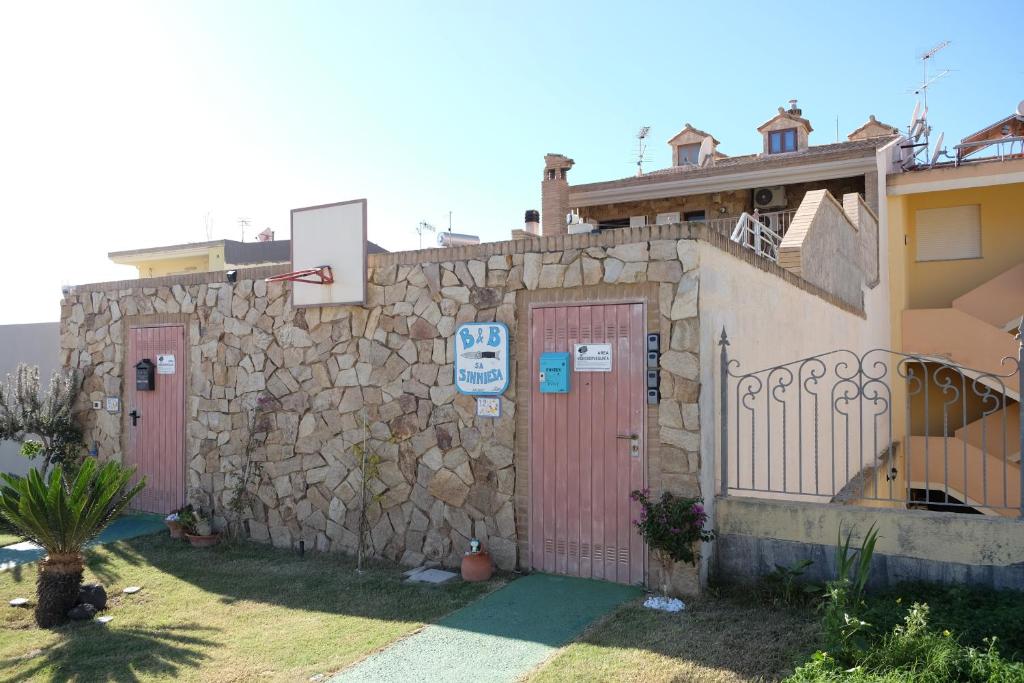 a stone wall with two doors and a basketball hoop at B&B Sa Sinniesa in Sìnnai