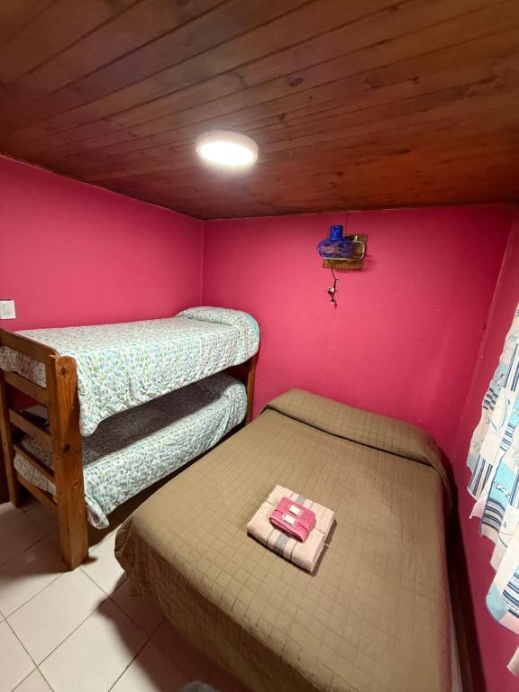 a room with two bunk beds and a pink wall at Complejo Corrientes Dpto 3 in Jesús María