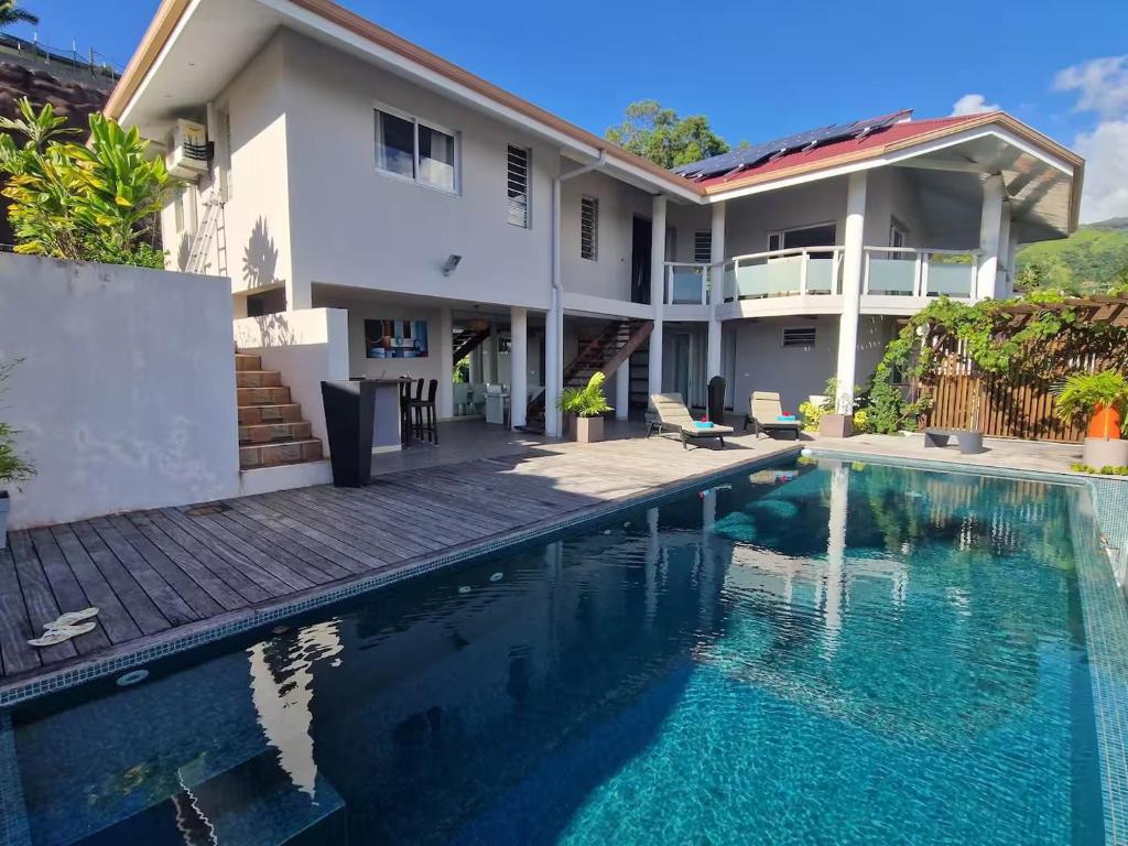 een huis met een zwembad ervoor bij Villa ATA ITI in Punaauia