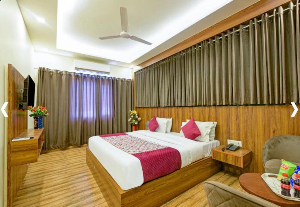 a bedroom with a bed and a couch and a tv at Hotel Rosewood New Delhi & Free Airport Drop in New Delhi