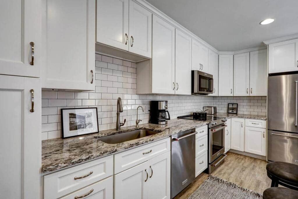 a kitchen with white cabinets and stainless steel appliances at THE HAMILTON HOUSE - DOWNTOWN COLONIAL LANCASTER in Lancaster
