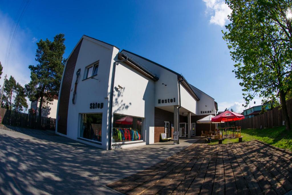 a white building with a red umbrella on a street at Trafo Base Camp in Kroczyce