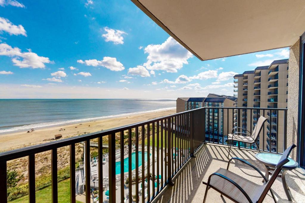 een balkon met stoelen en uitzicht op het strand bij Sea Colony - 1005N Edgewater House Rd in Sea Colony