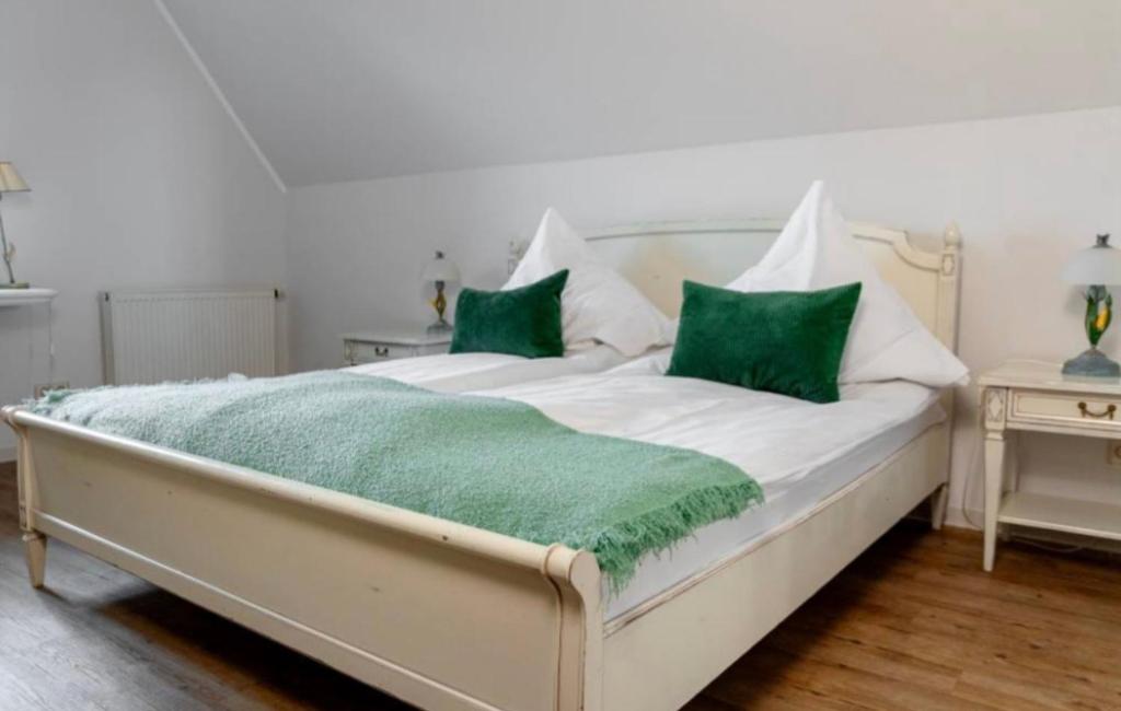 a large white bed with green pillows on it at Landgasthaus Zum Engel in Neuleiningen