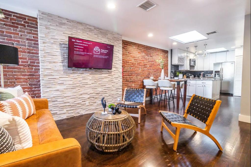 ein Wohnzimmer mit einem Sofa, Stühlen und einer Ziegelwand in der Unterkunft Family-Friendly Apartment with Kitchen in San Diego