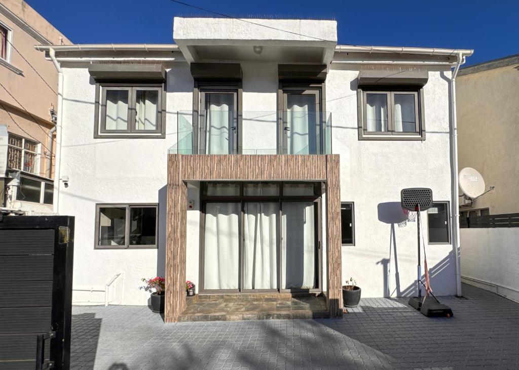 a white house with a wooden door in front of it at Villa Paradis à 100m de la plage in Flic-en-Flac