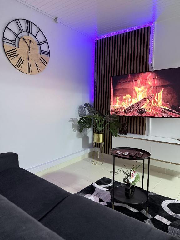 a living room with a clock and a fireplace at Smylie home in Fort-de-France