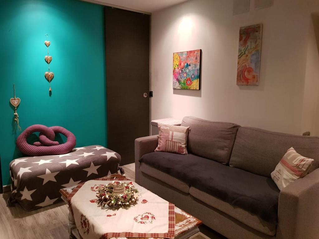 a living room with a couch and a ottoman at Domaine au Grès des Pierres in Flexbourg