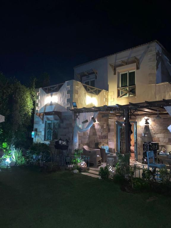 a house with lights on the front of it at night at Villa hossam elkady in Maḩaţţat Wardān