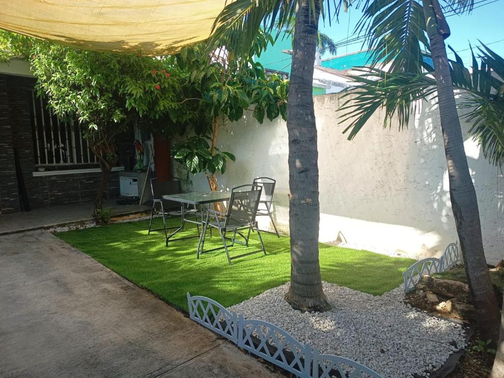 カンクンにあるCasa Nomada 28 Cancunのヤシの木が植わるパティオ(テーブル、椅子付)