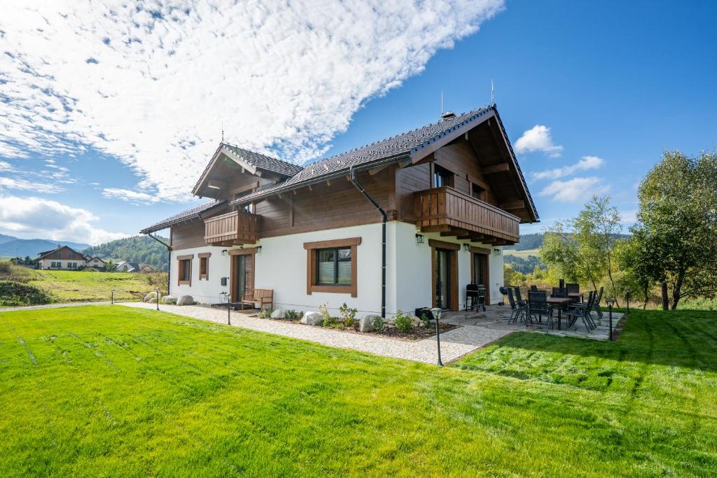 a house with a green lawn in front of it at Chalet Karolína in Zuberec