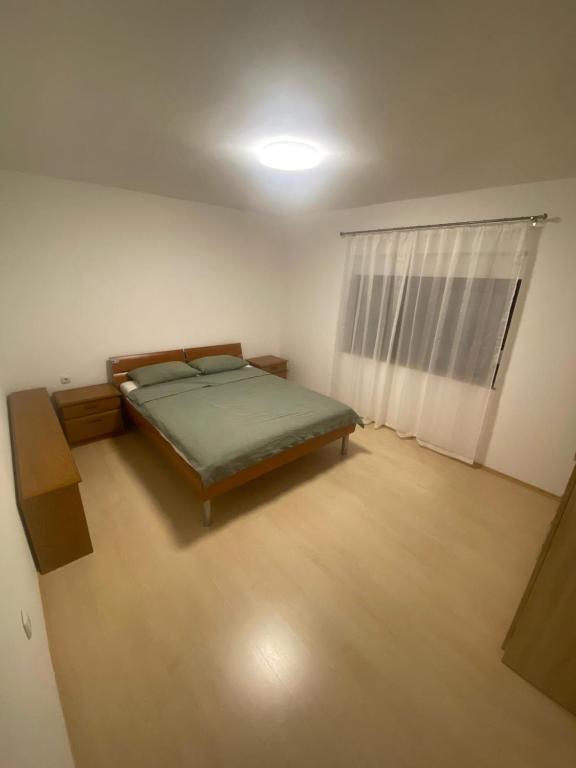 a small bedroom with a bed and a window at Apartman Dinja in Posušje