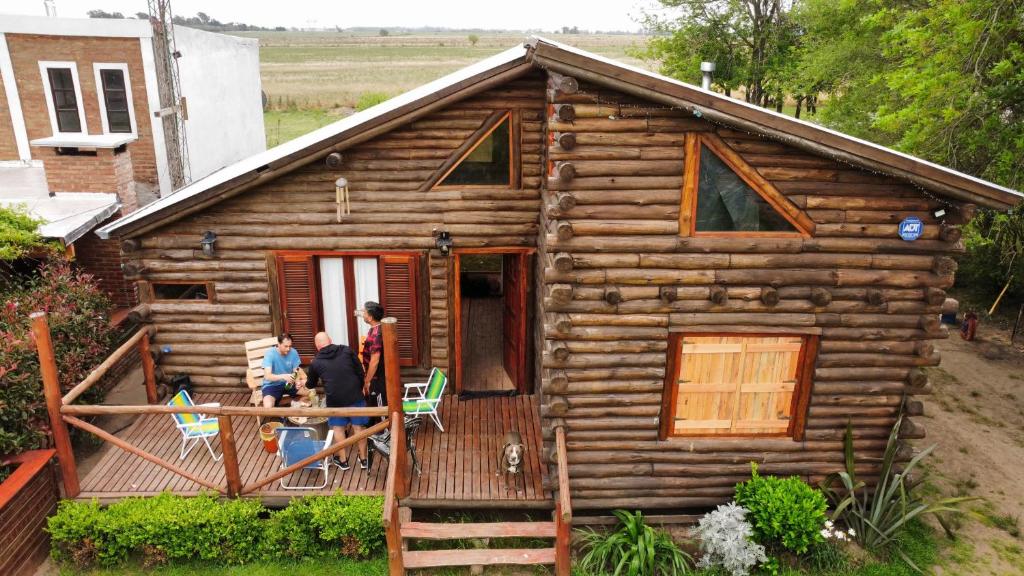 two people standing on the porch of a log cabin at La cabaña in Sánchez