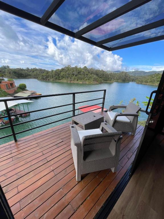 een terras met stoelen en uitzicht op een rivier bij Boreal Glamping in Guatapé
