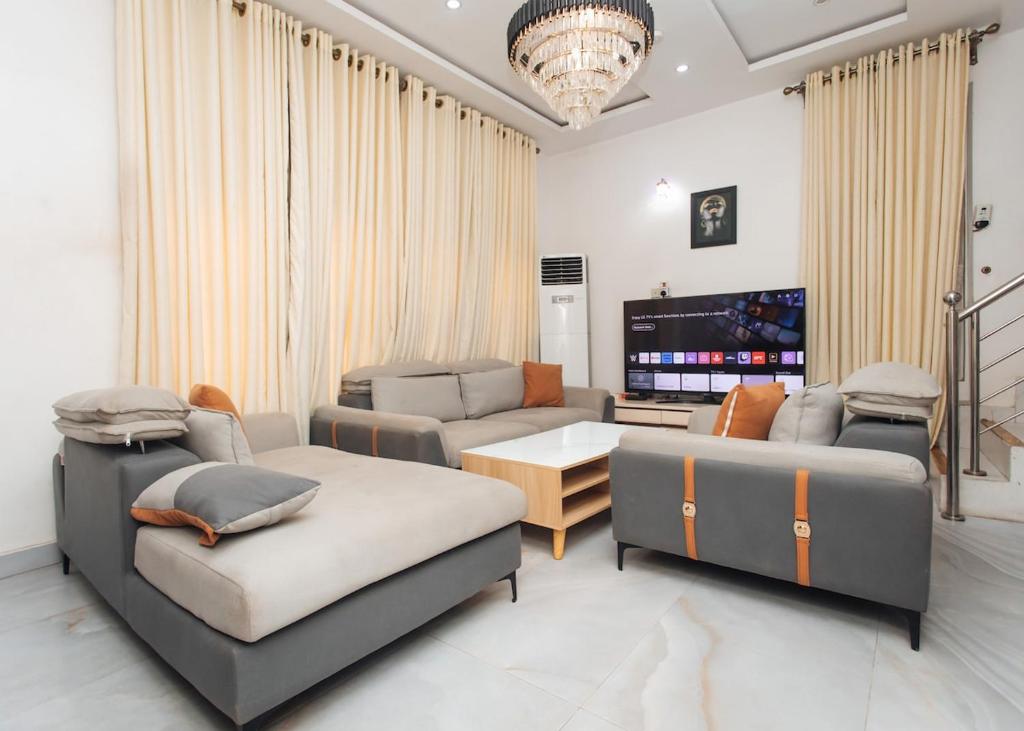 a living room with two couches and a television at Tranquil 5BR Duplex in Lekki in Maiyegun