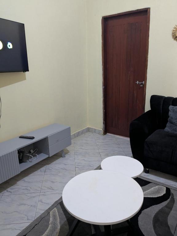 a living room with two white tables and a tv at Masaka Haven in Masaka