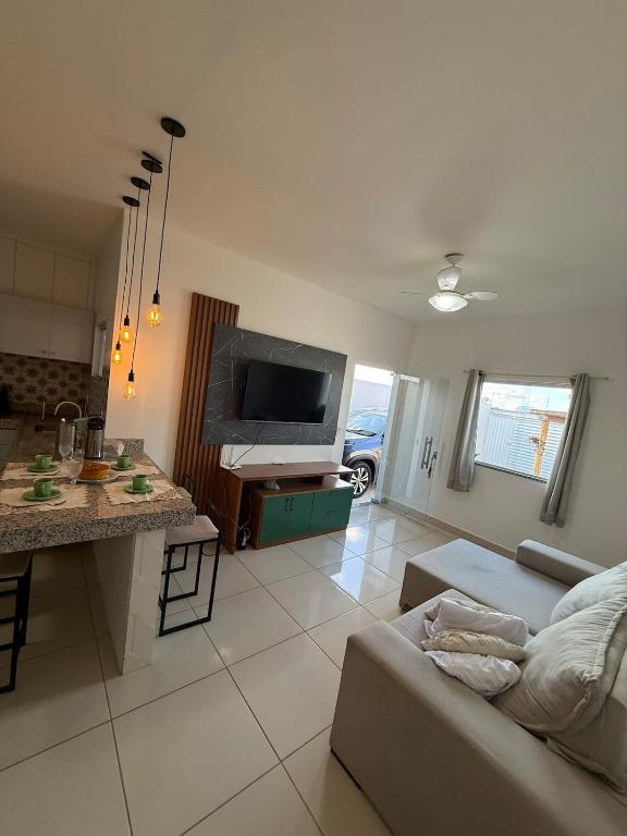 a living room with a couch and a tv at Casa aconhegante e cheirosa in Nanuque