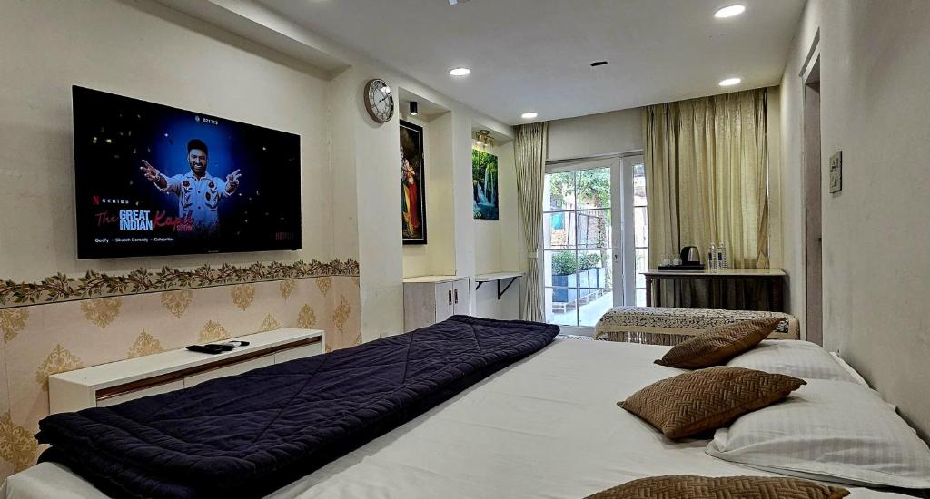 ein Schlafzimmer mit einem großen Bett und einem Fernseher an der Wand in der Unterkunft Shanti Niwas Jodhpur, Rajasthan in Jodhpur