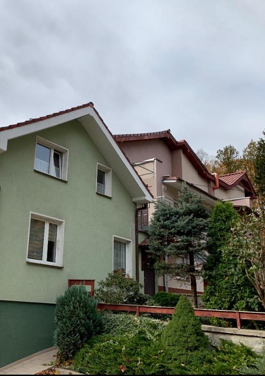 a green house with a fence in front of it at Willa Justynka in Bystrzyca Górna